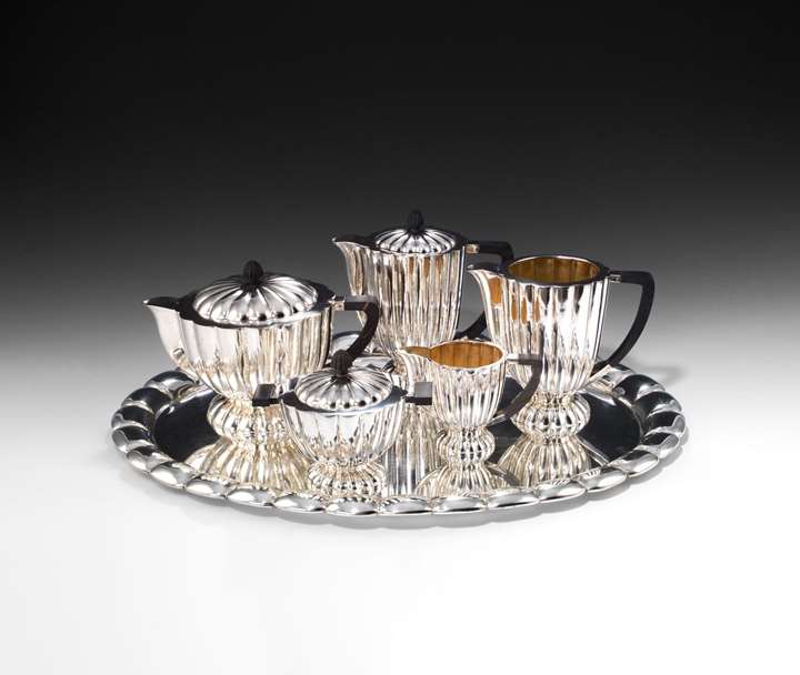 ART DECO SILVER TEA AND COFFEE SERVICE
consisting of: teapot, coffeepot, creamer, water or milk jug, lidded sugar bowl, oval tray